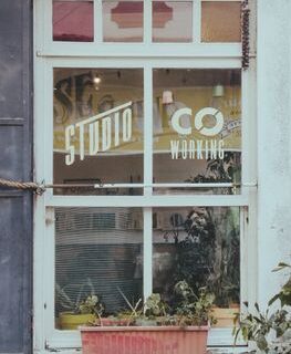 Co-working studio window with reflections in İstanbul, Türkiye. Urban vibe with potted plants.