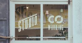Co-working studio window with reflections in İstanbul, Türkiye. Urban vibe with potted plants.